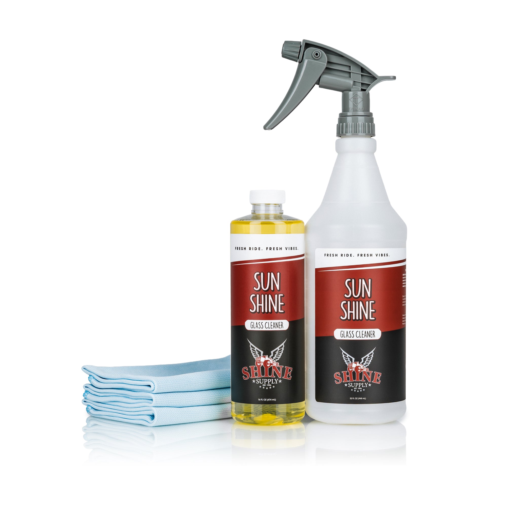 Shine Supply Sun Shine Glass Cleaning Kit with a 16 oz bottle of Sun Shine glass cleaner concentrate, a labeled 32 oz Sun Shine spray bottle, and a stack of blue Look Out glass towels